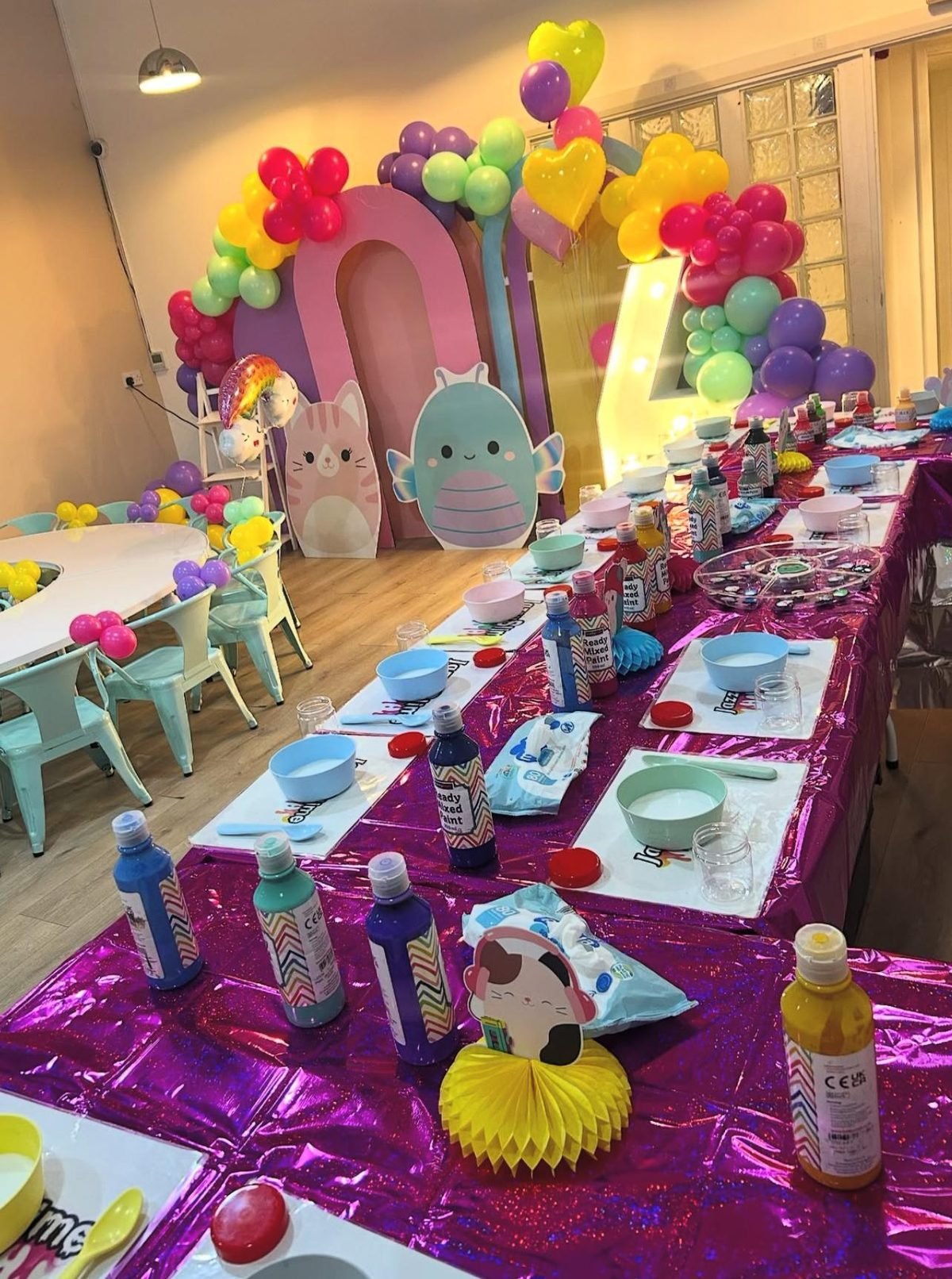 Rainbow Squishmallow themed party balloon arch