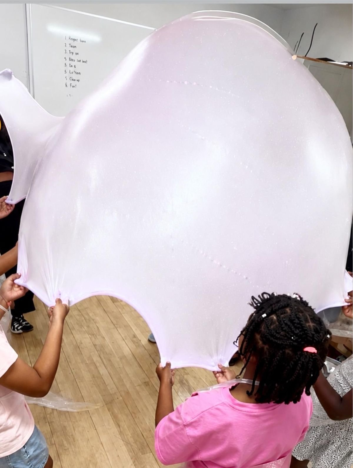 Children working together to create one giant slime at an Ultimate Slime Party